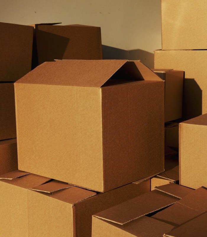 Stacked cardboard boxes ready for shipping or storage in a warehouse setting.